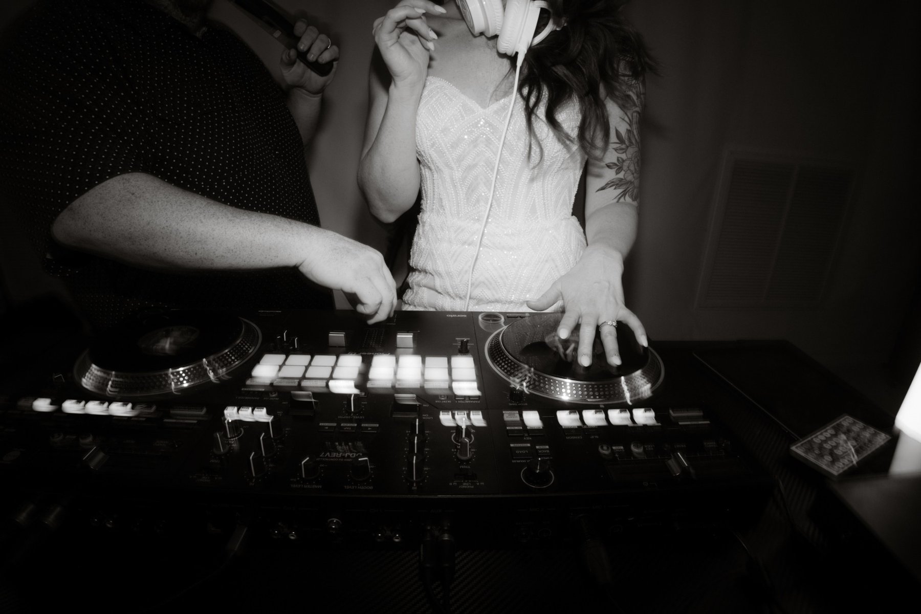 Bride scratching into a song behind DJ Puff’s controller during her wedding reception