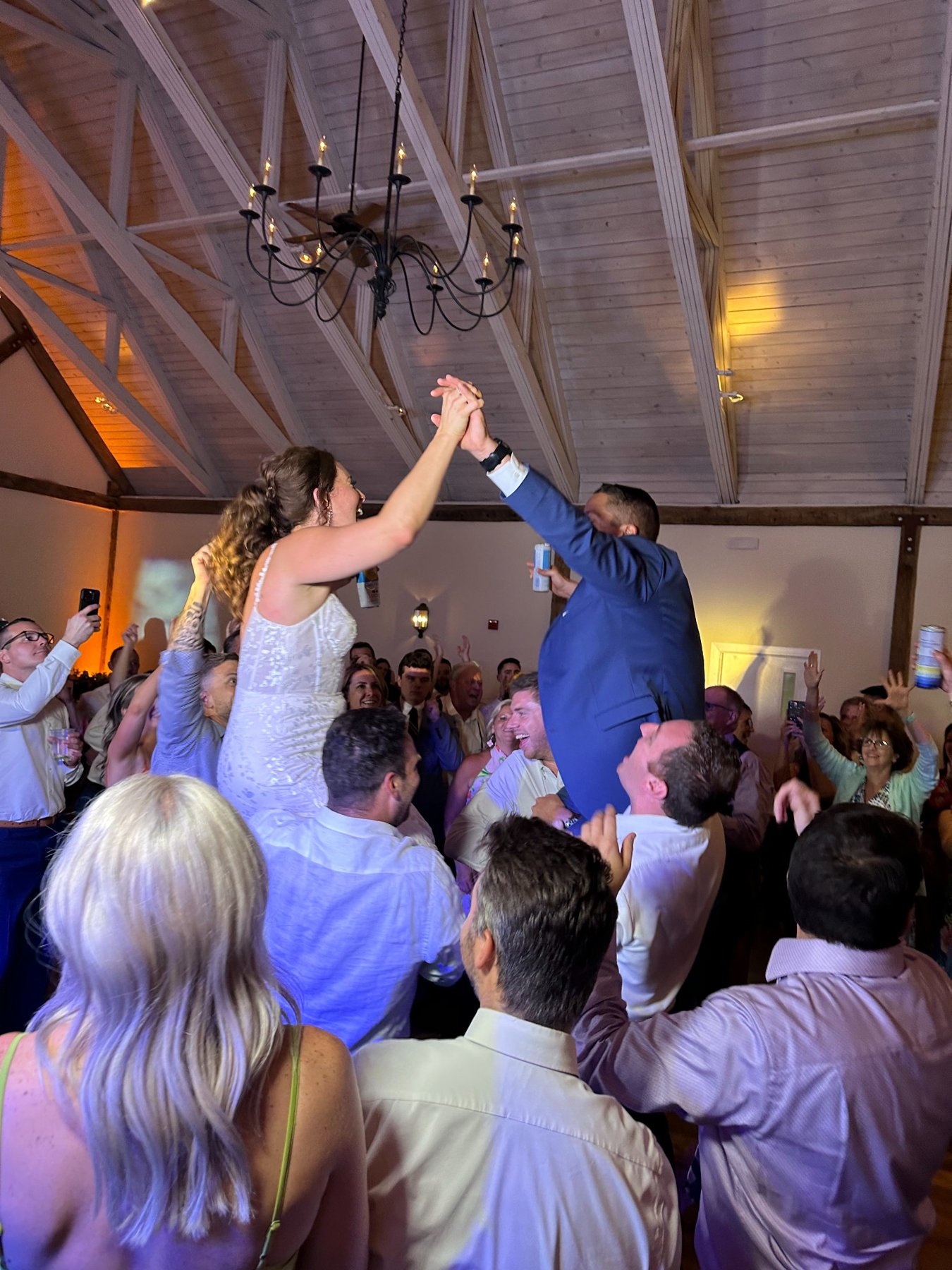 Newlyweds celebrating above a crowd of cheering wedding guests