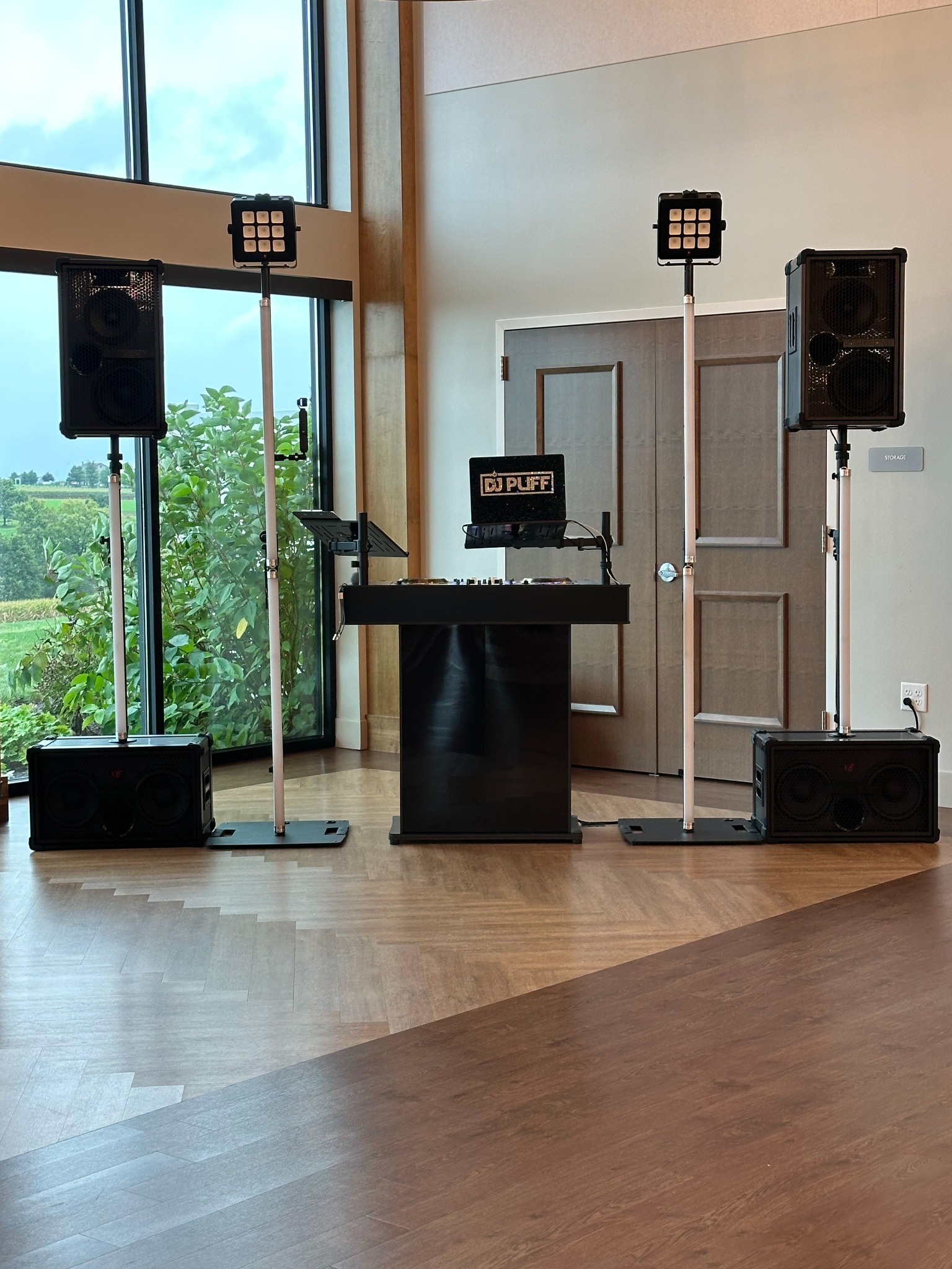 A clean wedding DJ setup positioned against the wall of a reception space